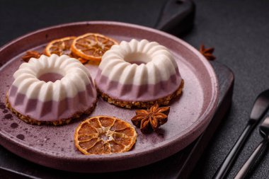 Lezzetli yuvarlak pembe ve beyaz cheesecake laktozsuz, şekersiz, sağlıklı beslenme koyu beton arka planda