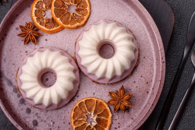 Lezzetli yuvarlak pembe ve beyaz cheesecake laktozsuz, şekersiz, sağlıklı beslenme koyu beton arka planda