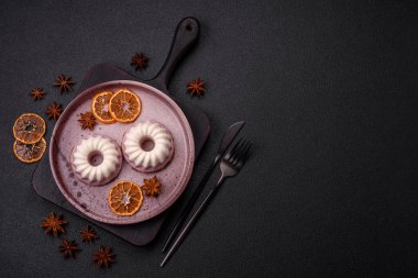 Lezzetli yuvarlak pembe ve beyaz cheesecake laktozsuz, şekersiz, sağlıklı beslenme koyu beton arka planda