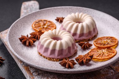 Lezzetli yuvarlak pembe ve beyaz cheesecake laktozsuz, şekersiz, sağlıklı beslenme koyu beton arka planda