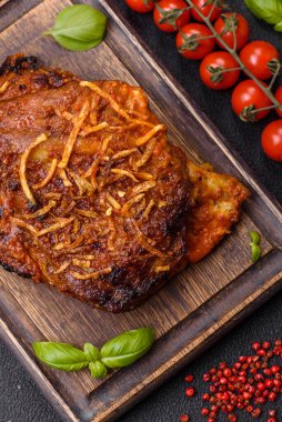 Izgarada pişirilmiş lezzetli domuz ya da biftek pirzolası. Koyu beton arka planda tuz, baharat ve otlarla birlikte.