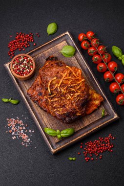 Izgarada pişirilmiş lezzetli domuz ya da biftek pirzolası. Koyu beton arka planda tuz, baharat ve otlarla birlikte.