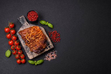 Izgarada pişirilmiş lezzetli domuz ya da biftek pirzolası. Koyu beton arka planda tuz, baharat ve otlarla birlikte.