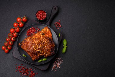 Izgarada pişirilmiş lezzetli domuz ya da biftek pirzolası. Koyu beton arka planda tuz, baharat ve otlarla birlikte.