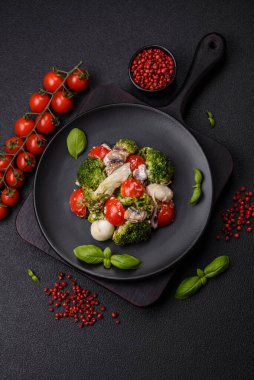 Lezzetli taze salata, bıldırcın yumurtaları, kiraz domatesleri, tuzlu marul yaprakları, baharatlar ve koyu beton arka planda otlar.