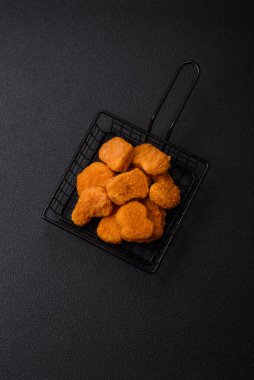 Delicious fresh crispy chicken nuggets on a dark concrete background. Unhealthy food, fast food