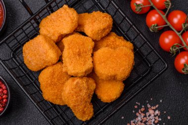 Delicious fresh crispy chicken nuggets on a dark concrete background. Unhealthy food, fast food
