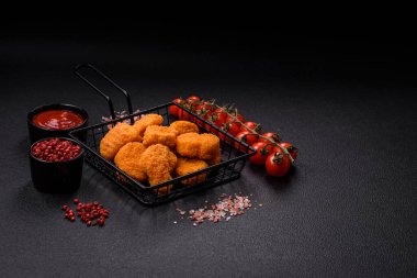 Delicious fresh crispy chicken nuggets on a dark concrete background. Unhealthy food, fast food