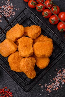 Delicious fresh crispy chicken nuggets on a dark concrete background. Unhealthy food, fast food