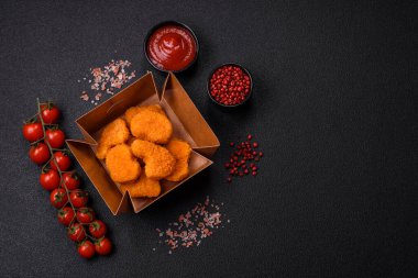 Koyu beton arka planda lezzetli çıtır tavuk nuggetları. Sağlıksız yemek, fast food