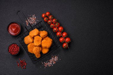 Delicious fresh crispy chicken nuggets on a dark concrete background. Unhealthy food, fast food