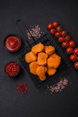 Delicious fresh crispy chicken nuggets on a dark concrete background. Unhealthy food, fast food
