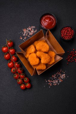 Koyu beton arka planda lezzetli çıtır tavuk nuggetları. Sağlıksız yemek, fast food