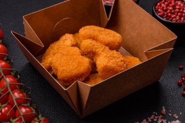 Delicious fresh crispy chicken nuggets on a dark concrete background. Unhealthy food, fast food