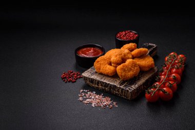 Delicious fresh crispy chicken nuggets on a dark concrete background. Unhealthy food, fast food