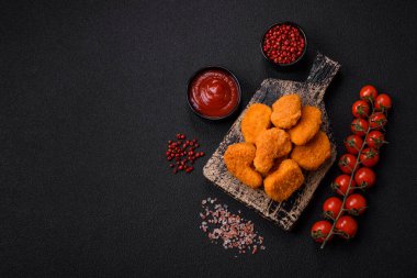 Koyu beton arka planda lezzetli çıtır tavuk nuggetları. Sağlıksız yemek, fast food