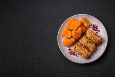 Delicious hearty vegetarian or vegan dish in the form of cutlets or patties consisting of potatoes, carrots, onions and beans on a dark concrete background