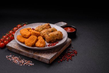 Delicious hearty vegetarian or vegan dish in the form of cutlets or patties consisting of potatoes, carrots, onions and beans on a dark concrete background
