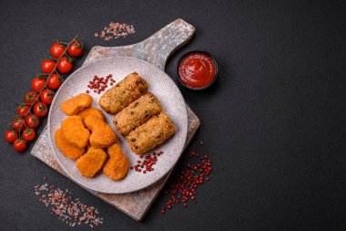 Delicious hearty vegetarian or vegan dish in the form of cutlets or patties consisting of potatoes, carrots, onions and beans on a dark concrete background