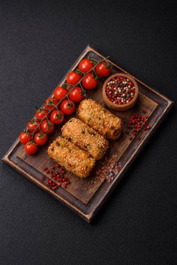Delicious hearty vegetarian or vegan dish in the form of cutlets or patties consisting of potatoes, carrots, onions and beans on a dark concrete background