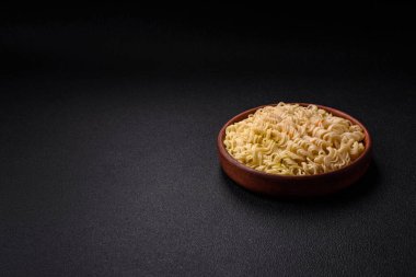 Lezzetli Asya yemeği pirinç eriştesi ya da koyu beton arka planda sebzeli, baharatlı ve otlu udon.