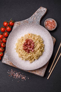 Lezzetli Asya yemeği pirinç eriştesi ya da koyu beton arka planda sebzeli, baharatlı ve otlu udon.