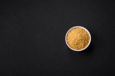 Koyu beton zemin üzerinde tuz ve baharatlı buğdaydan ham stelline makarna