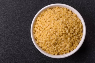 Koyu beton zemin üzerinde tuz ve baharatlı buğdaydan ham stelline makarna