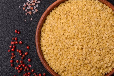 Koyu beton zemin üzerinde tuz ve baharatlı buğdaydan ham stelline makarna