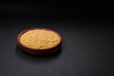 Koyu beton zemin üzerinde tuz ve baharatlı buğdaydan ham stelline makarna