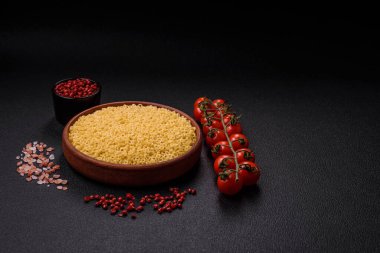 Koyu beton arka planda tuzlu ve baharatlı buğdaydan ham anellini makarna.