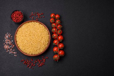 Koyu beton arka planda tuzlu ve baharatlı buğdaydan ham anellini makarna.