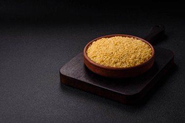 Koyu beton arka planda tuzlu ve baharatlı buğdaydan ham anellini makarna.