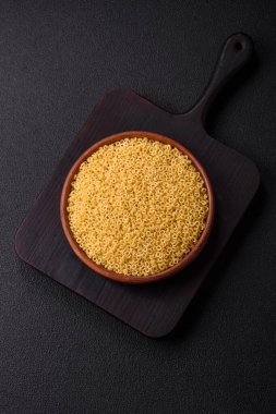 Koyu beton arka planda tuzlu ve baharatlı buğdaydan ham anellini makarna.