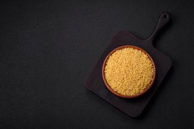 Koyu beton arka planda tuzlu ve baharatlı buğdaydan ham anellini makarna.