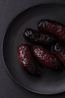 Lezzetli siyah kan sosisi veya siyah beton arka planda ızgara baharat ve otlu kara puding.