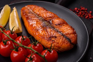 Taze pişirilmiş lezzetli somon bifteği, baharatlar ve ızgarada pişirilmiş otlar. Sağlıklı deniz ürünleri