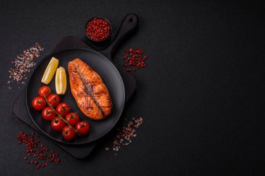 Taze pişirilmiş lezzetli somon bifteği, baharatlar ve ızgarada pişirilmiş otlar. Sağlıklı deniz ürünleri