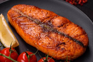 Taze pişirilmiş lezzetli somon bifteği, baharatlar ve ızgarada pişirilmiş otlar. Sağlıklı deniz ürünleri