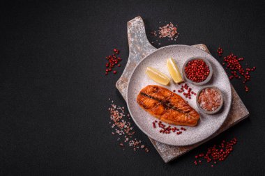 Taze pişirilmiş lezzetli somon bifteği, baharatlar ve ızgarada pişirilmiş otlar. Sağlıklı deniz ürünleri