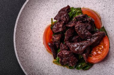 Lezzetli tavuk ciğeri, ıspanak, roka, tuzlu domates, baharat ve çimento kaplı bitki salatası.