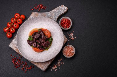 Lezzetli tavuk ciğeri, ıspanak, roka, tuzlu domates, baharat ve çimento kaplı bitki salatası.