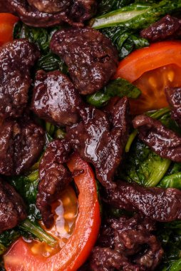 Lezzetli tavuk ciğeri, ıspanak, roka, tuzlu domates, baharat ve çimento kaplı bitki salatası.