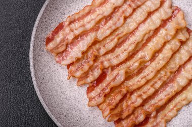 Tuz, baharat ve otlarla dilimlenmiş lezzetli pastırma koyu beton arka planda.