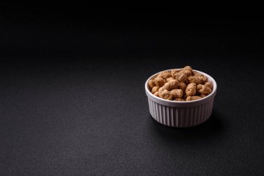 Kuru soya fasulyesi topakları, vejetaryen ve vejetaryen mutfağı için diyet yiyecekler koyu beton arka planda.