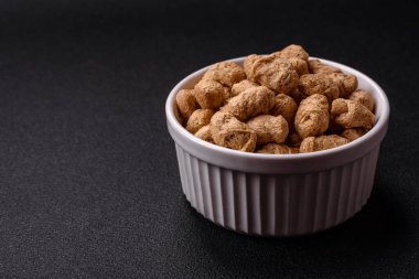 Kuru soya fasulyesi topakları, vejetaryen ve vejetaryen mutfağı için diyet yiyecekler koyu beton arka planda.