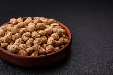 Kuru soya fasulyesi topakları, vejetaryen ve vejetaryen mutfağı için diyet yiyecekler koyu beton arka planda.