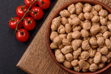 Kuru soya fasulyesi topakları, vejetaryen ve vejetaryen mutfağı için diyet yiyecekler koyu beton arka planda.