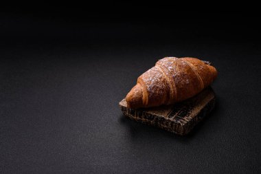 Lezzetli çıtır kruvasan, koyu beton arka planda çikolata dolgulu.