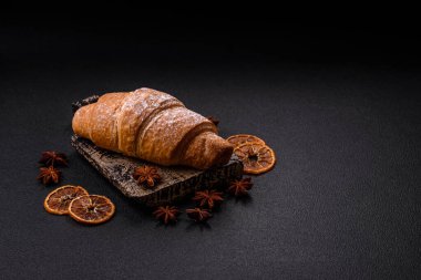 Lezzetli çıtır kruvasan, koyu beton arka planda çikolata dolgulu.